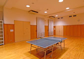 ツヤのある板張りの部屋の中央に卓球台がある。